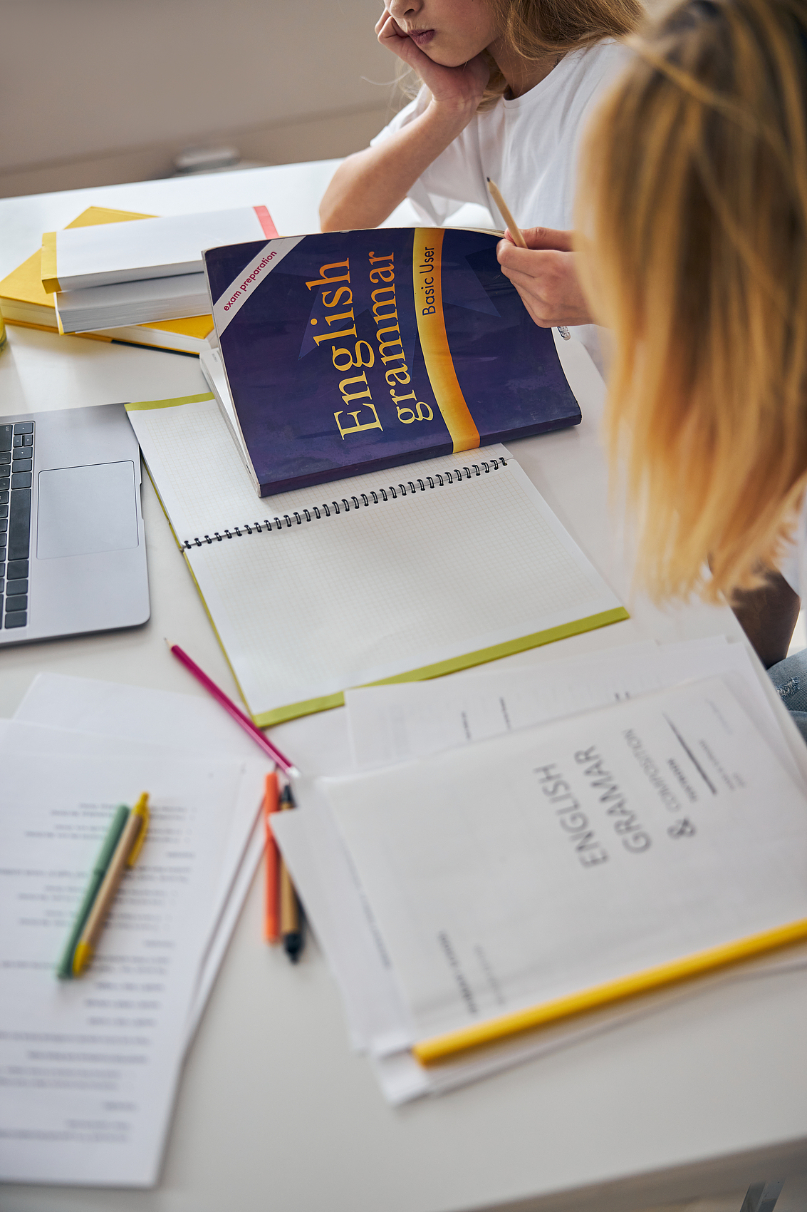 Student workbook and writing materials on a desk